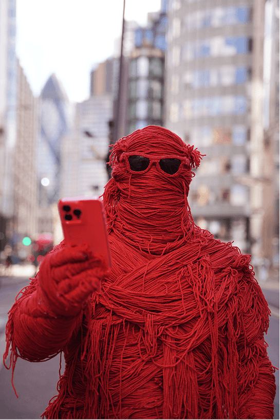 Fred taking a photo on his phone in the City of London
