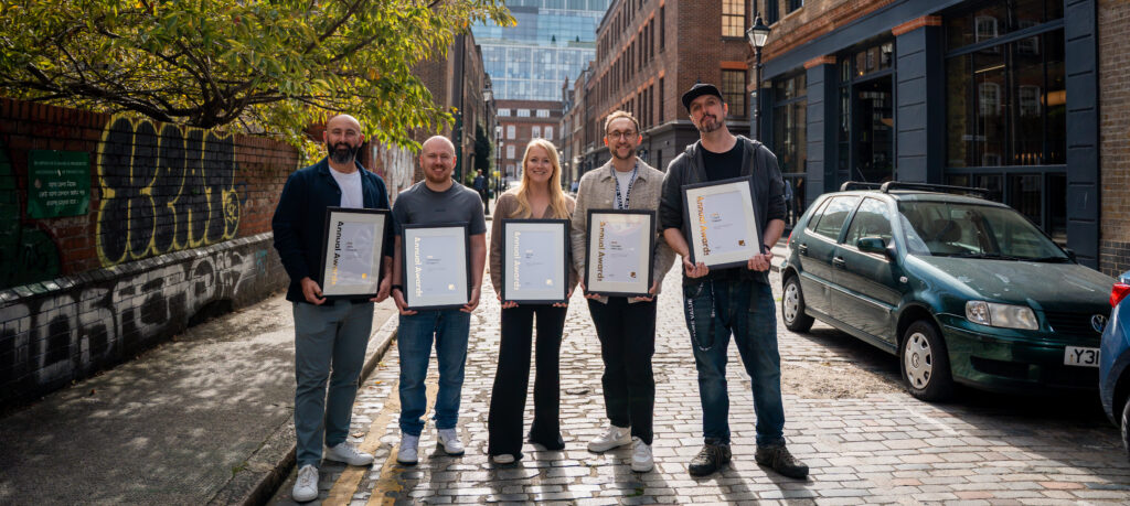 All of the annual award winners holding their award certificates in a London street