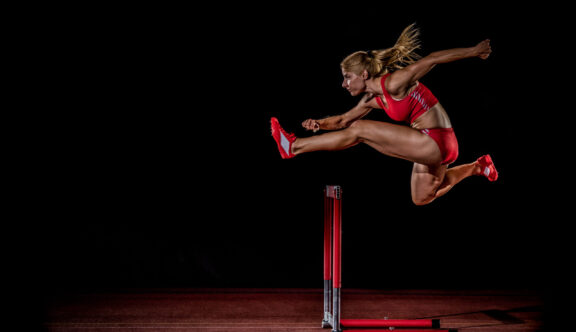 Athlete clearing hurdle