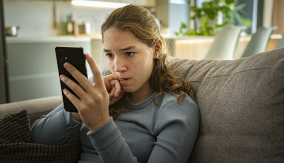 A teen girl scrolling on her phone