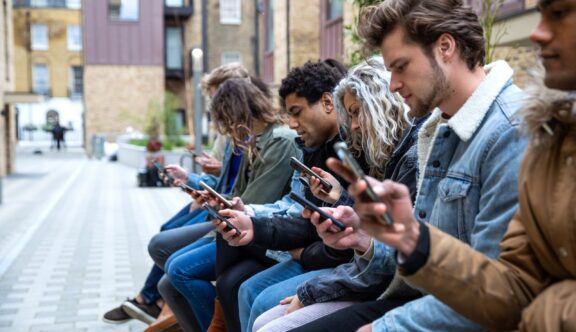 Group of teenage friend focused on their own smartphone texting on social media