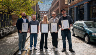 All of the annual award winners holding their award certificates in a London street